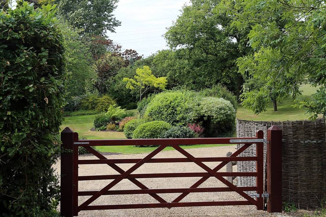 Wooden garden gate and fence beside a lawn